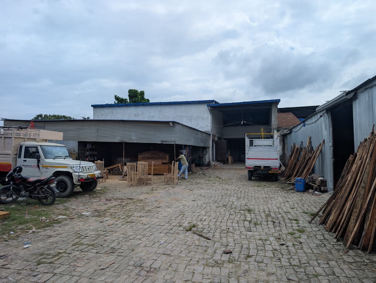 The yard at the works, sheds on both sides and sawn boards stacked against the far wall
