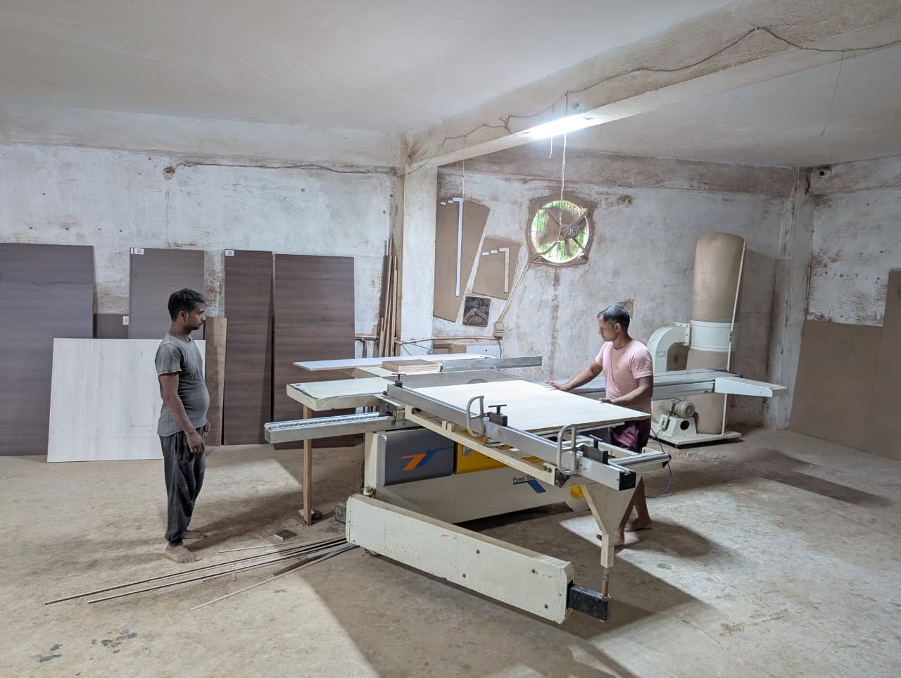 The cutting room, with finished panels stacked along the wall behind the sliding saw