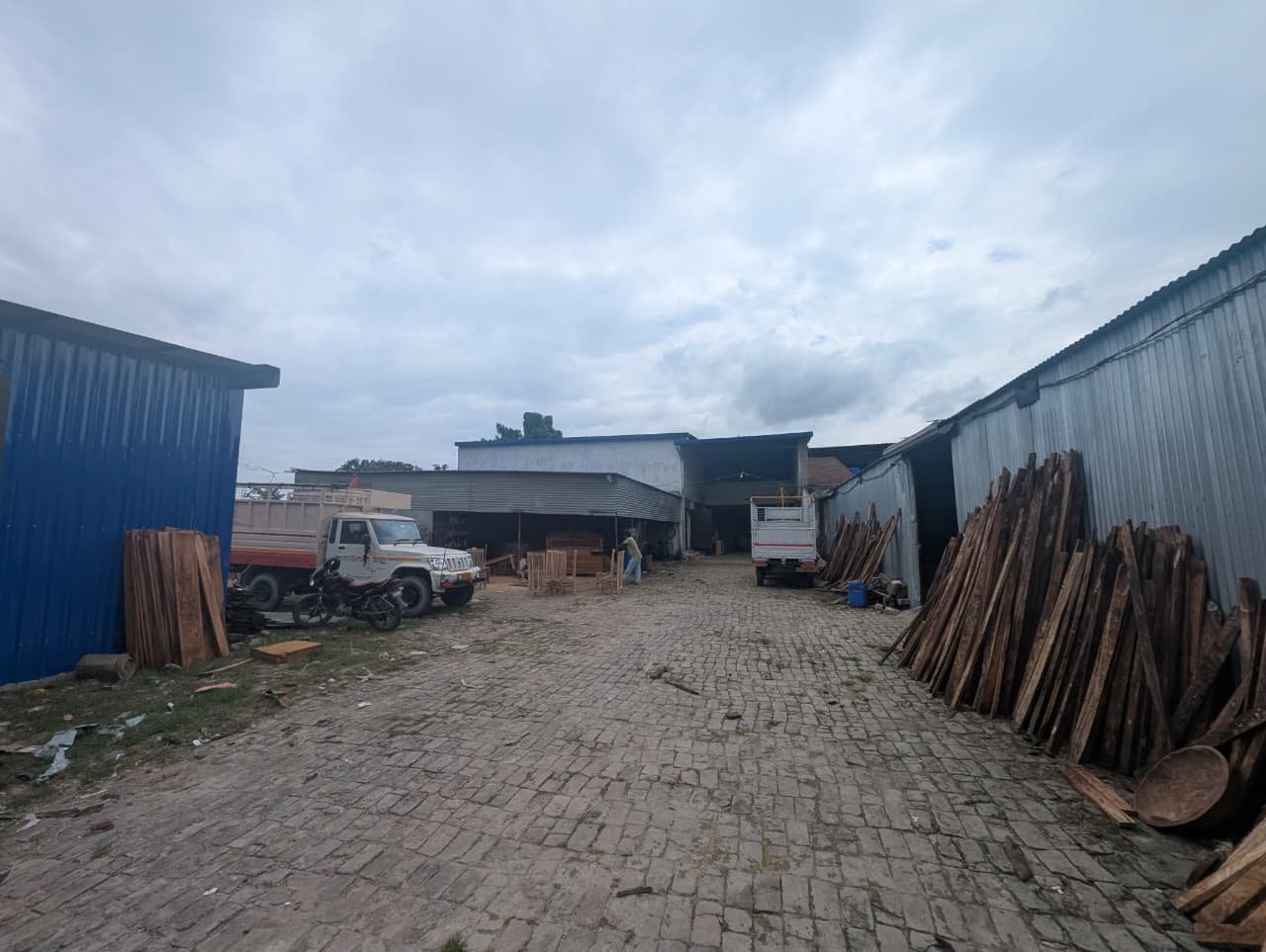 Sawn boards standing on end along the shed wall in the works yard